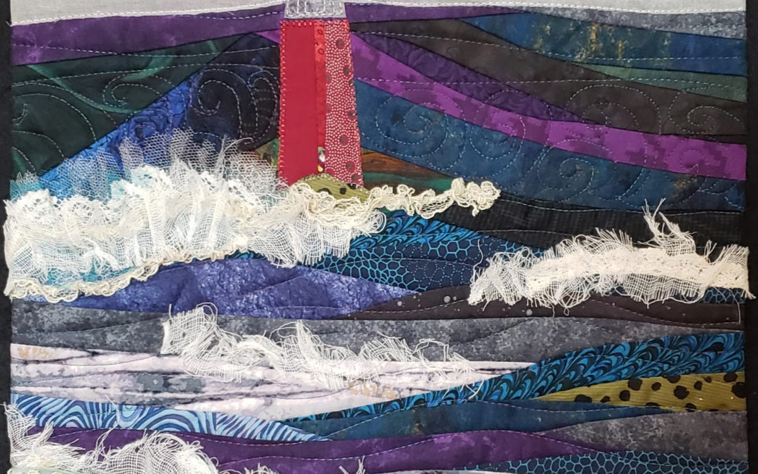 image of a light house at night during a big storm. Rendered in textiles, it includes pieces of lace and cheesecloth as waves, burlap as sand and real shark's teeth washed up on shore.